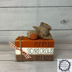 a small pumpkin sitting on top of a stack of books with the words pumpkins scarecrows tiny rides