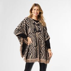 Say hello to your new favorite layering piece - the Kendall Ruana! With its trendy toggle closure, playful fringe accents, and one size versatility, this ruana will take your outfit to the next level. Materials: Acrylic/Polyester. Oversized Fringe Cape For Fall, Fringe Cape Outerwear For Fall, Fall Fringe Cape Outerwear, Winter Cape With Tassels, One Size Poncho With Tassels In Cape Shape, Fringed Cape Poncho For Fall, Fringe Poncho Cape For Fall, Fringe Cape Poncho For Fall, Fall Fringe Cape Poncho