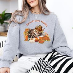 Celebrate the spirit of Thanksgiving with our adorable "Paws & Give Thanks" Cat Thanksgiving Sweatshirt! Perfect for cat lovers who want to showcase their love for their furry friends while embracing the warmth and gratitude of the holiday season. This cozy sweatshirt features a charming design of a cat surrounded by fall-themed elements, making it a must-have for Thanksgiving gatherings, cozy autumn days, or as a thoughtful gift for fellow cat enthusiasts. Whether you're cuddling up by the fire Cat Thanksgiving, Thanks Funny, Cat Napping, Autumn Walk, Thanksgiving Sweatshirt, Funny Thanksgiving Shirts, Holiday Meal, Autumn Days, Thanksgiving Shirt