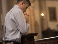 a man is praying in a church