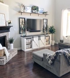 a living room filled with furniture and a flat screen tv mounted on a wall above a fireplace