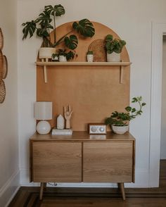 a wooden cabinet with plants on it in a living room