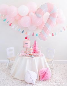 a pink birthday party with balloons, cake and decorations