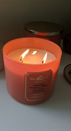 an orange candle sitting on top of a table