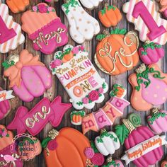 some decorated cookies are laying on a wooden table and one is for the first birthday