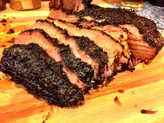 sliced up meat sitting on top of a wooden cutting board