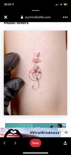 a small flower tattoo on the back of a woman's stomach