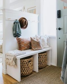 a white bench with baskets and hats on it