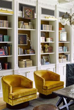 a living room filled with furniture and bookshelves covered in lots of bookcases