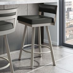 two black and white barstools in front of a counter with a view of the city