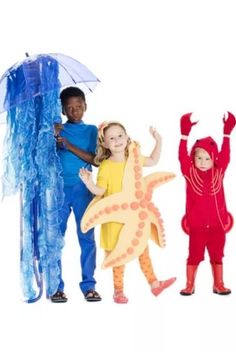 three children in costumes standing next to each other with an umbrella and starfish costume on