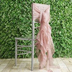 a chair with a pink ruffled seat cover sitting in front of a green wall