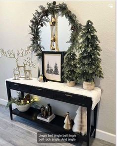 a table with christmas decorations on it and a mirror above the table in front of it