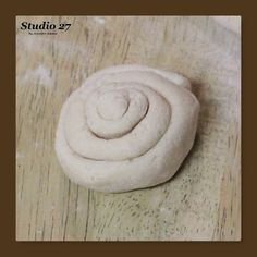 a rolled up dough sitting on top of a wooden table