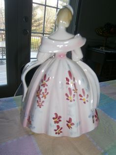 a ceramic tea pot sitting on top of a table next to a window in a room