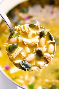 a spoon full of soup with beans and spinach