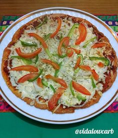 a pizza on a plate with cheese and vegetables