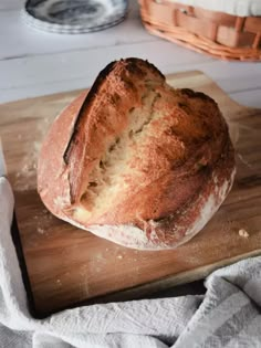 a loaf of bread sitting on top of a wooden cutting board