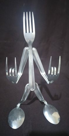 a fork and two spoons sitting on top of each other with forks attached to it