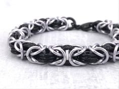 Classic Unisex Black and Platinum Silver Byzantine Anodized Aluminum Chainmaille Bracelet. I made it with care one ring at a time. Complete the effect by adding the Tierracast Lock and Key Toggle Clasp using this link and I'll include the charm for free: https://www.etsy.com/listing/1213157389 The bracelet can also act as a key holder for the matching Choker listed below! WRIST MEASUREMENT: When selecting the wrist measurement for you, please carefully measure your wrist where you intend to wear Black Stainless Steel Chainmail Jewelry, Black Punk Style Chain Bracelet As Gift, Punk Style Black Chain Bracelet Gift, Black Punk Style Chain Bracelet For Gift, Black Punk Chain Bracelet As A Gift, Adjustable Black Chainmail Jewelry, Black Hypoallergenic Metal Bracelets, Black Metal Hypoallergenic Bracelets, Hypoallergenic Black Metal Bracelets