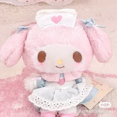 a pink stuffed animal with a white dress on