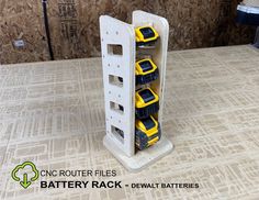 there are several yellow and black batteries in the storage rack on the floor next to a wall