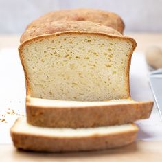 a loaf of bread sitting on top of a cutting board next to a slice of bread