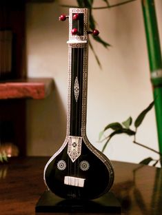 a black and white instrument sitting on top of a table next to a potted plant