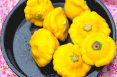 some yellow flowers are in a black bowl