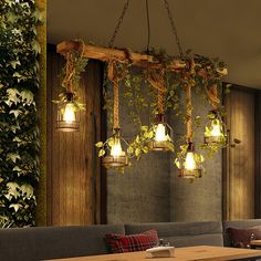 a restaurant with plants growing on the wall and lights hanging from it's ceiling