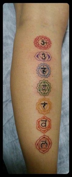 a woman's leg with seven chakras on it