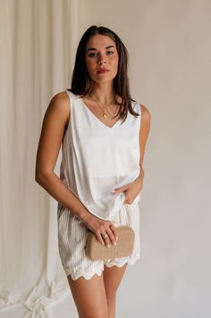 Introducing our Monroe Off White Satin Tank Top, a luxurious essential that epitomizes elegance and versatility. Crafted from sumptuously soft satin fabric in a timeless off-white hue, this tank top exudes sophistication with every wear. The graceful v-neckline adds a touch of allure, framing your décolletage with understated charm. Whether dressed up with statement jewelry for a night out or paired with casual denim for a relaxed daytime look, the Monroe Tank effortlessly transitions from day t Satin Tank Top, Travel Dress, Jumpsuit Shorts Rompers, Maxi Dresses Casual, Romper Pants, White Satin, Casual Denim, Guest Dresses, Satin Fabric