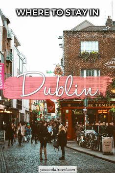 there is a sign that says where to stay in dublin with people walking down the street