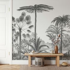 a living room with a table and wallpaper that has palm trees on the wall