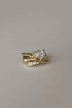 two gold wedding rings with three diamonds on each one, set against a plain background