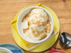 two bowls of ice cream on plates with spoons