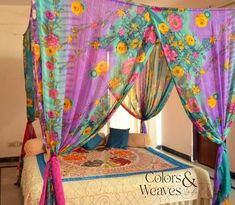 the canopy bed is decorated with colorful flowers and ribbons on it's headboard