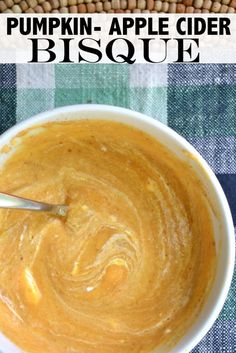 pumpkin - apple cider bisque recipe in a white bowl with a spoon inside