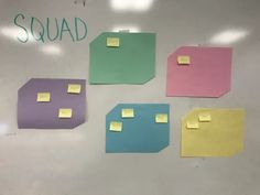 sticky notes are attached to the back of a whiteboard