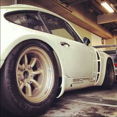 a white car parked in a garage next to other cars