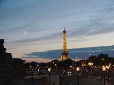 the eiffel tower is lit up at night