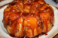 a bundt cake covered in caramel sauce and pecans on a white plate