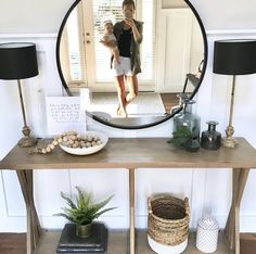 a woman taking a selfie in front of a mirror on a table with some plants