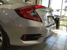 the rear end of a white car in a showroom