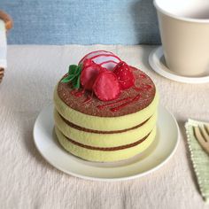 there is a cake with strawberries on it and a coffee cup next to it