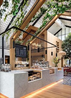 the inside of a restaurant with plants growing on the wall