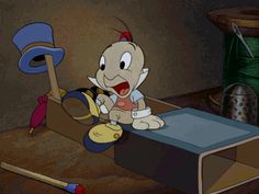 a cartoon character sitting on top of a desk next to a hat and baseball bat