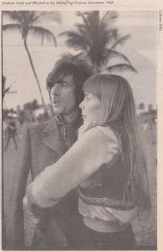 two people standing next to each other on a beach