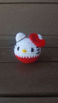 a crocheted hello kitty keychain with a red hat on it's head