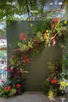 an outdoor display with plants and flowers on it's sides, in front of a swimming pool